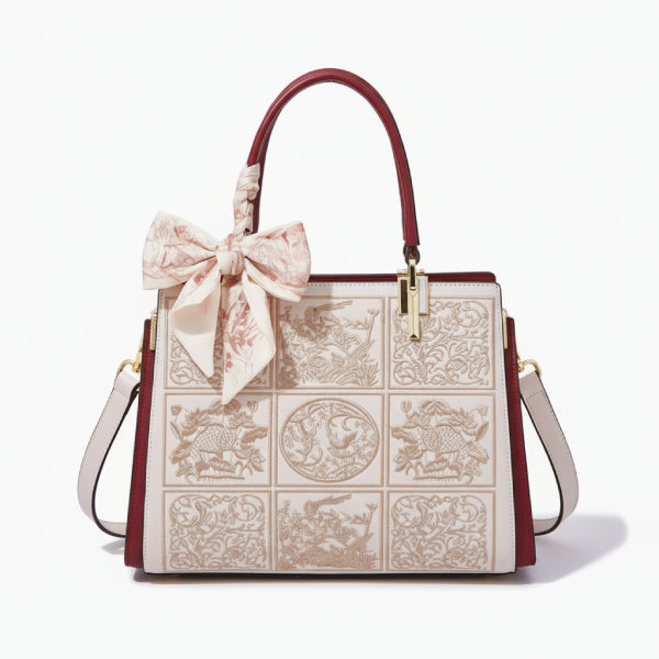 Front view of the off-white Elisandra embroidered tote bag, featuring detailed floral patterns and a stylish bow accent for a chic look
