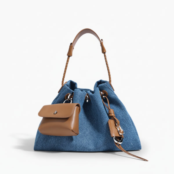 Evelisse Denim Bucket Bag in denim blue, front studio view showcasing soft bucket silhouette, detachable mini pouch, and drawstring closure