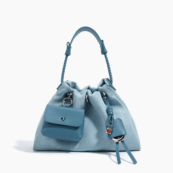 Evelisse Denim Bucket Bag in light blue, front studio view showcasing soft bucket silhouette with detachable mini pouch and drawstring closure