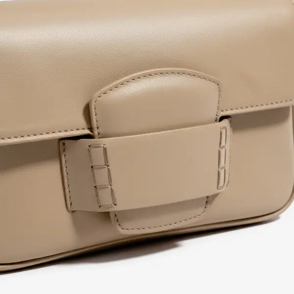 Close-up of the Faelina genuine cowhide shoulder bag in apricot featuring a distinctive buckle closure