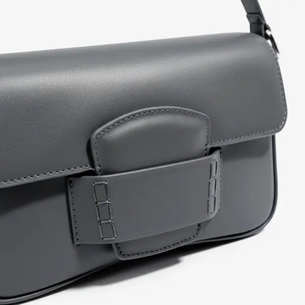 Close-up of the Faelina genuine cowhide shoulder bag in gray highlighting the sleek buckle closure and smooth leather finish