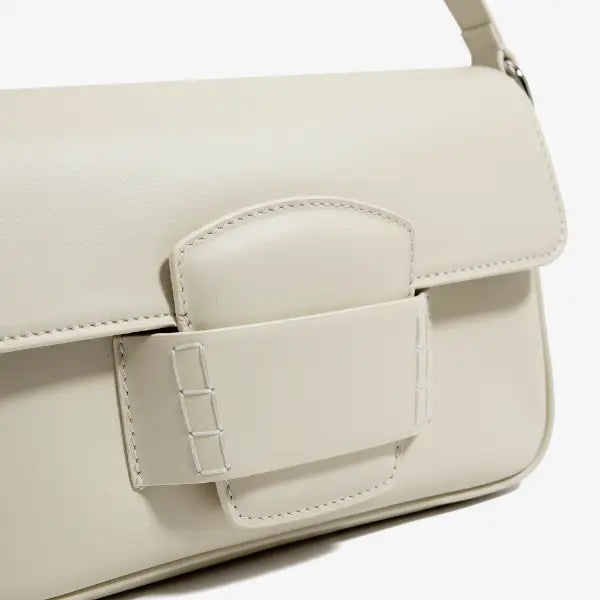 Close-up of the Faelina genuine cowhide shoulder bag in off-white showcasing the clean buckle closure and smooth leather texture