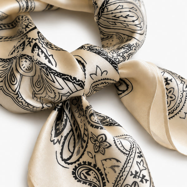 Beige scarf with black paisley pattern on a white background