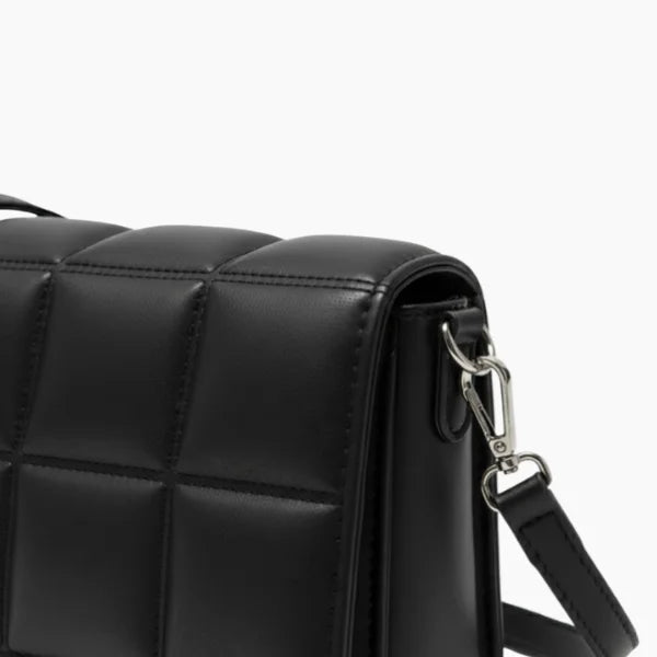 Isla Vegan Leather Crossbody Bag in black, closeup of padded stitching, silver hardware, and detachable strap clip