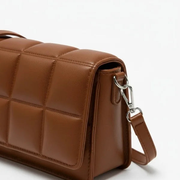 Isla Vegan Leather Crossbody Bag in brown, closeup highlighting quilted square panels, silver hardware, and detachable strap clip