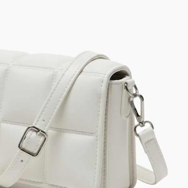 Isla Vegan Leather Crossbody Bag in white, closeup highlighting padded stitching, silver hardware, and detachable strap clip