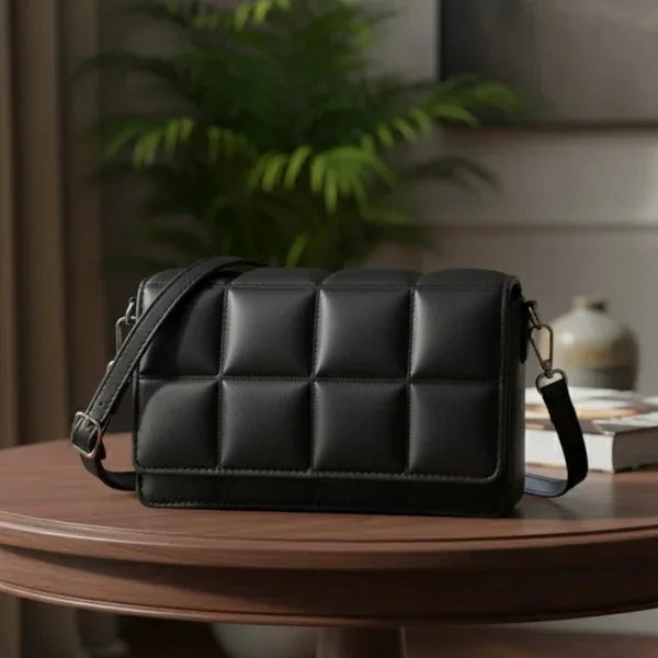 Isla Vegan Leather Crossbody Bag in black, tabletop studio view highlighting quilted square texture and structured silhouette