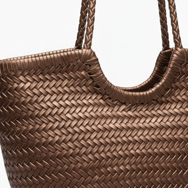 Close-up of a coffee leather woven tote bag with a glossy finish and beige drawstring closure