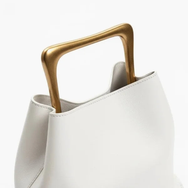 Close-up of a White Izelia top grain leather crossbody bag with gold handle on a white background