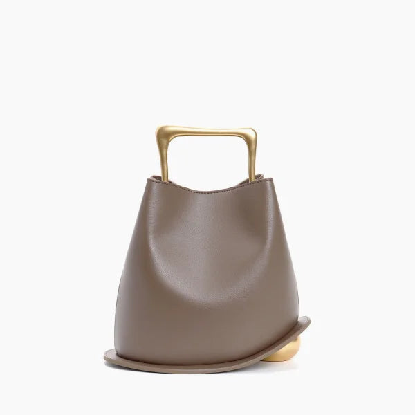Front view of a Taupe Izelia top grain leather crossbody bag with a gold handle on a white background