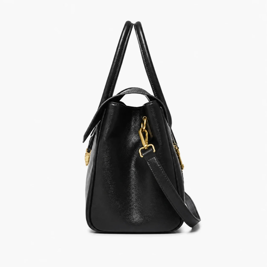 A black leather handbag with gold-tone hardware, featuring dual top handles and a detachable shoulder strap, shown against a plain white background.