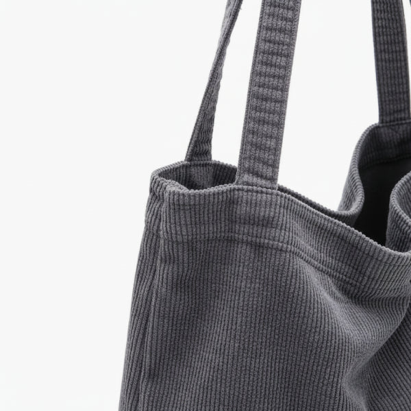 Close-up of the Marinda corduroy tote bag in grey, showcasing the textured fabric and handles