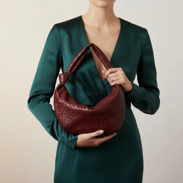 Maris Vegan Leather Hobo Bag in wine red, model holding compact hobo highlighting basketweave and elegant style