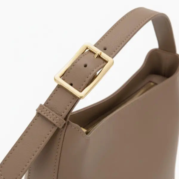 Closeup of Meliora vegan leather shoulder bag with adjustable strap and gold buckle in khaki color