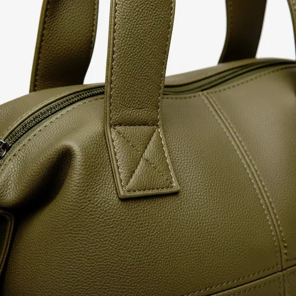 Close-up of Mirelith olive green leather satchel bag with quilted handles and adjustable straps with silver hardware