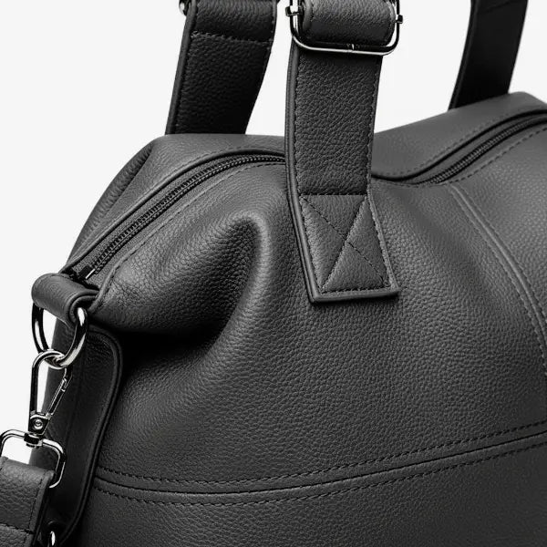Close-up of Mirelith grey leather satchel bag with quilted handles and adjustable strap with silver hardware