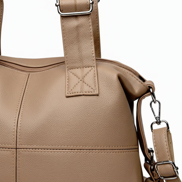 Close-up of Mirelith khaki leather satchel bag with quilted handles and adjustable strap with silver hardware