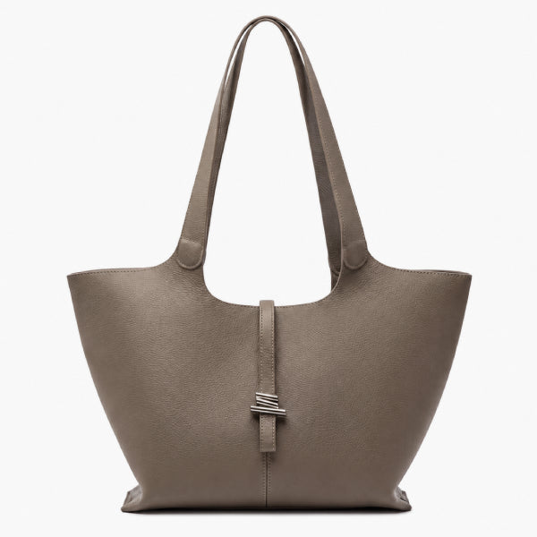 A taupe leather tote bag with dual shoulder straps and a central strap detail featuring a silver-toned metal accent, shown against a plain white background.