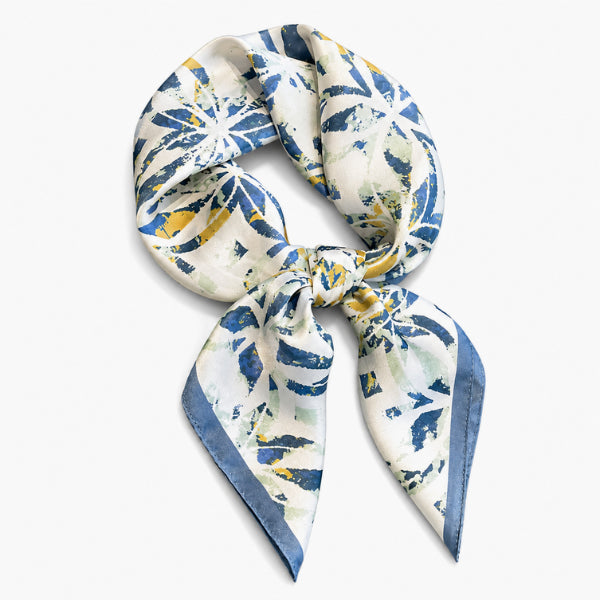 Floral patterned scarf tied in a knot on a white background