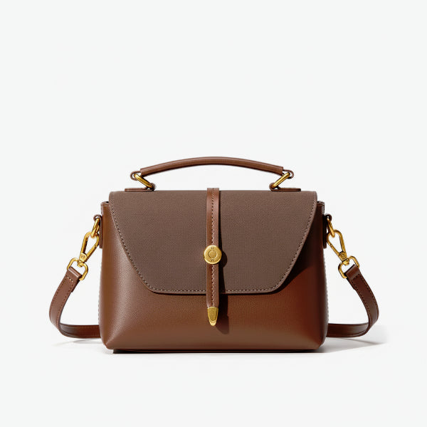 Front view of a brown vegan leather crossbody bag with a structured design, gold accents, and a top handle with adjustable shoulder strap
