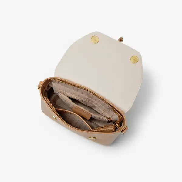 Interior view of a beige vegan leather crossbody bag showing the lined compartment and zipper pocket