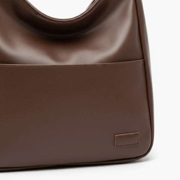 Closeup of Seliora vegan leather shoulder bag in coffee color with front pocket and sleek design