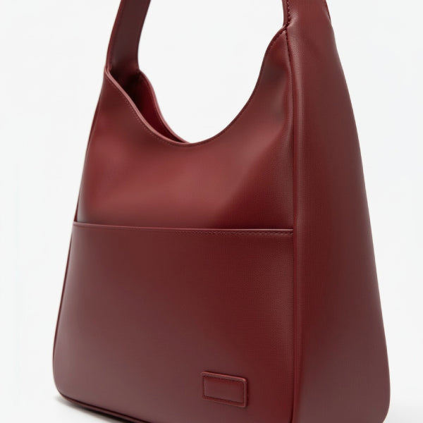 Closeup of Seliora vegan leather shoulder bag in wine red color with front pocket and sleek design