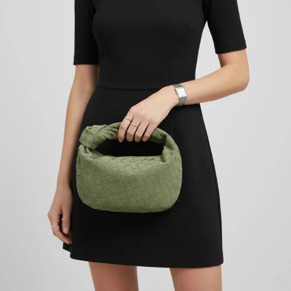 Seraphine Vegan Leather Hobo Bag in green, model in black dress holding mini woven hobo with knotted handle for evening style