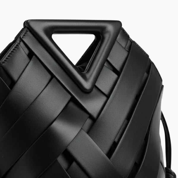 Seren Vegan Leather Bucket Bag in black, closeup highlighting geometric triangular handle and wide woven straps