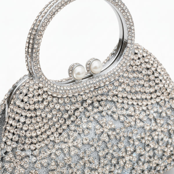 Close-up of serenna rhinestone evening bag in silver with intricate rhinestone design and pearl clasp