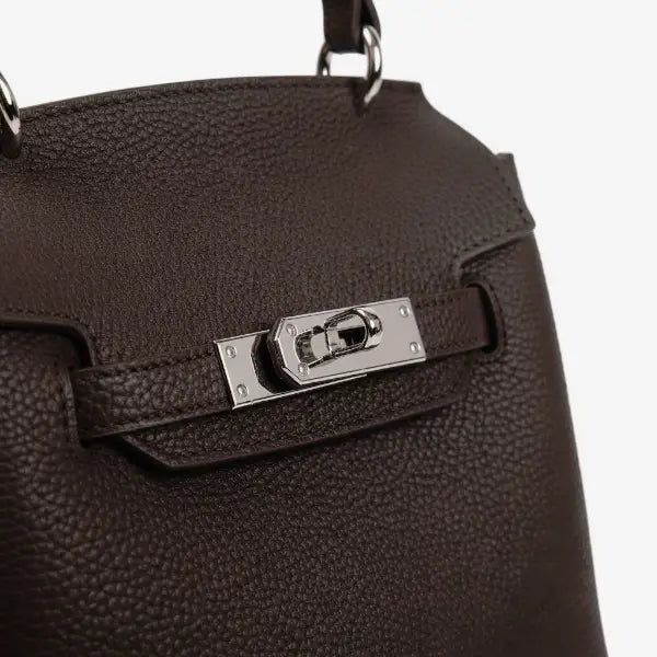 Close-up of the silver clasp on the coffee brown genuine leather satchel bag, highlighting the refined craftsmanship and rich leather texture