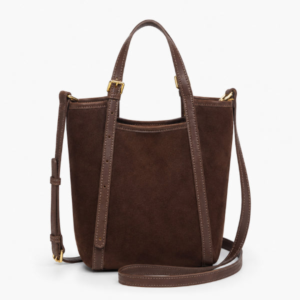 A dark brown suede bucket bag with matching brown leather trim, dual top handles, and a detachable shoulder strap, shown on a clean white background.