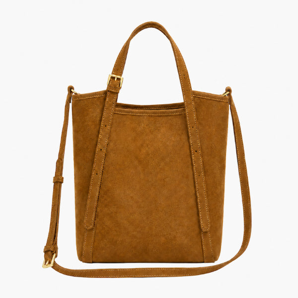 A tan suede bucket bag with dual top handles and a detachable shoulder strap, shown against a plain white background.