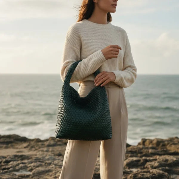 Soraya Vegan Leather Hobo Bag in dark green, lifestyle coastal scene with model holding large woven hobo for chic everyday style