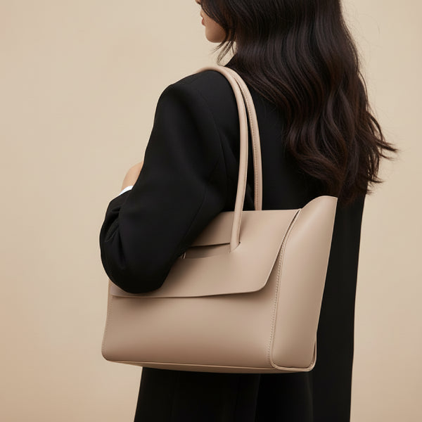 Model carrying the Sylvene vegan leather tote bag in khaki color, styled with a black blazer, demonstrating a chic and sophisticated look