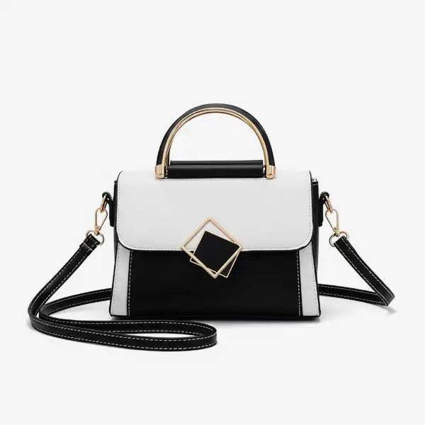 Front view of the black and white vegan leather satchel bag with a unique geometric design, featuring a gold-tone metal clasp