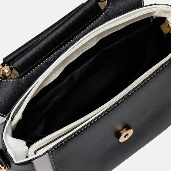 Interior shot of the black and white vegan leather satchel bag, showcasing its spacious compartment with smooth lining and secure closure