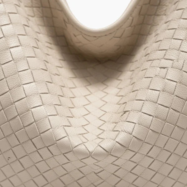 Close-up of white woven vegan leather hobo bag with detailed texture and smooth finish