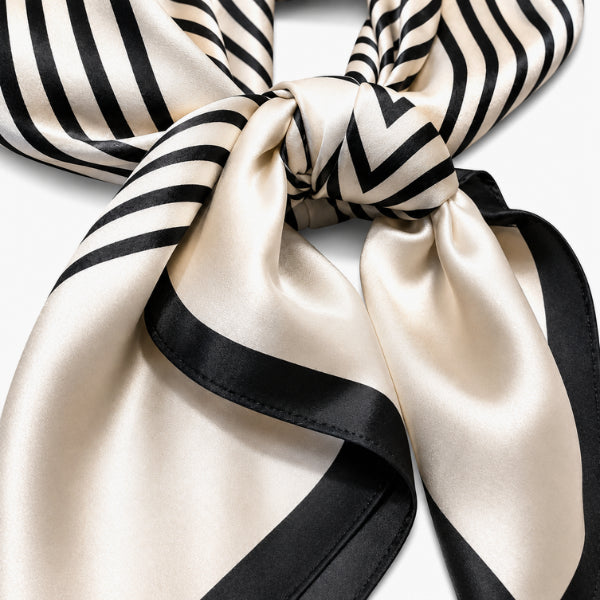 Black and white striped silk scarf tied in a knot on a white background