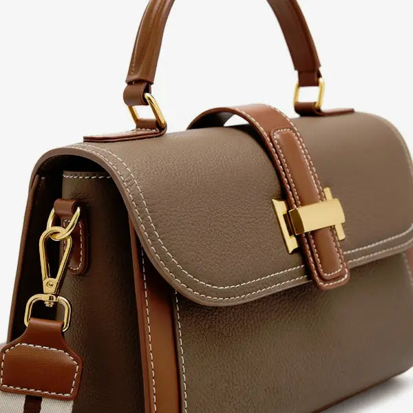 Close-up of the gold-tone clasp on the brown genuine leather satchel bag, emphasizing its premium craftsmanship and luxurious design