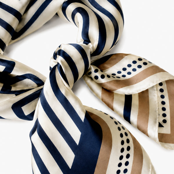 Striped and patterned scarf with blue, white, and brown colors on a white background