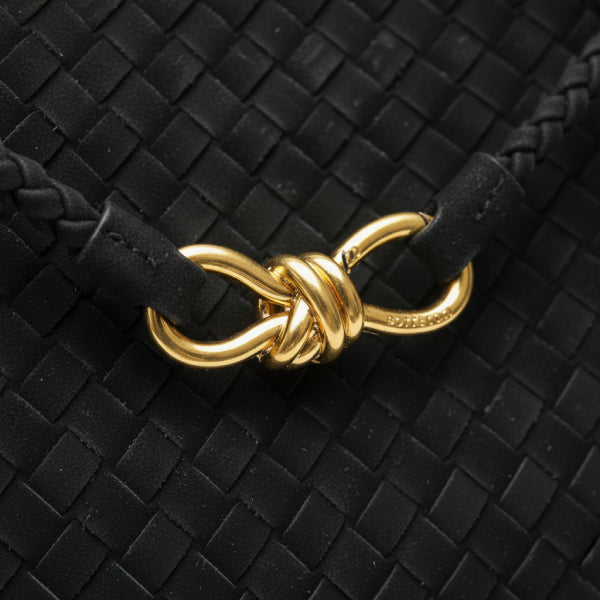 Close-up of the gold-tone knot closure on the Veyra vegan leather tote bag in black, highlighting the sleek woven texture