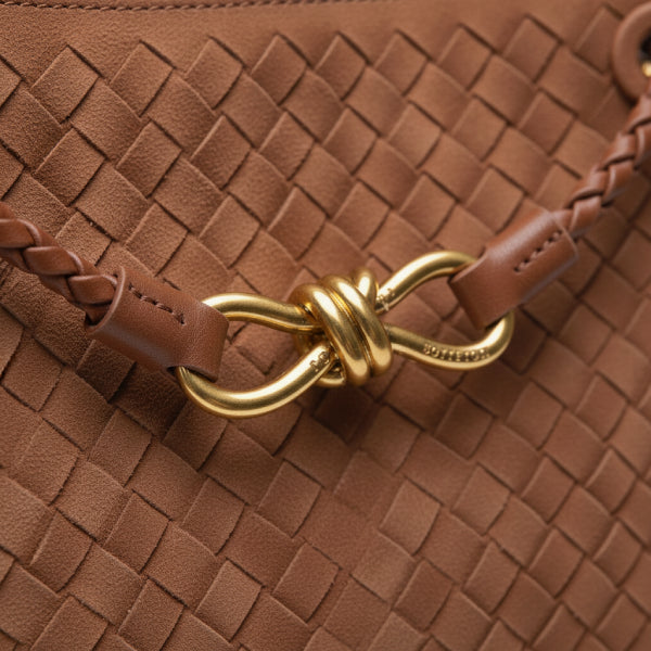 Close-up of the Veyra vegan leather tote bag in brown, featuring the intricate woven texture and elegant gold-tone knot closure
