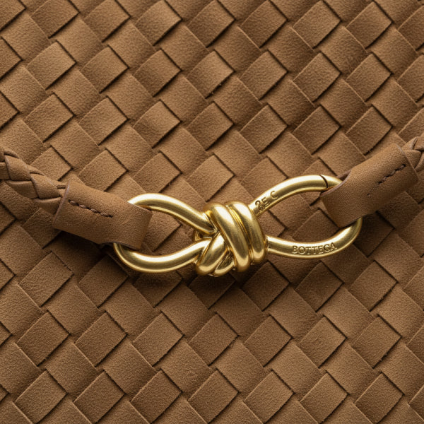 Close-up of the Veyra vegan leather tote bag in caramel color, highlighting the braided leather strap and gold-tone knot closure