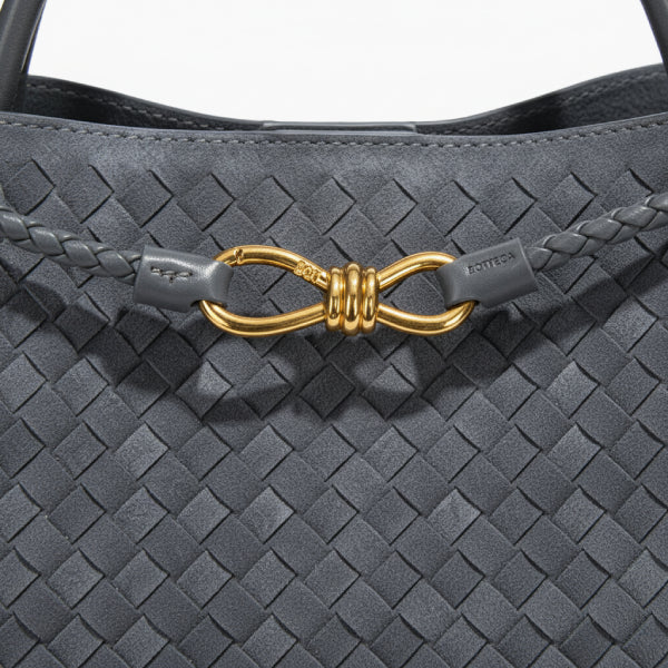 Close-up of the Veyra vegan leather tote bag in gray, featuring a braided leather strap and gold-tone knot closure, highlighting its elegant design