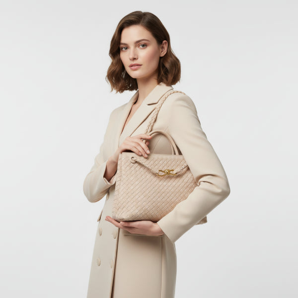 Model holding the Veyra vegan leather tote bag in beige, styled with a beige coat, showcasing a chic and modern look