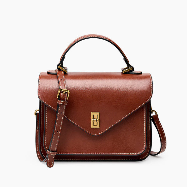 Front view of the brown genuine leather satchel bag with gold-tone hardware, offering a structured and elegant design